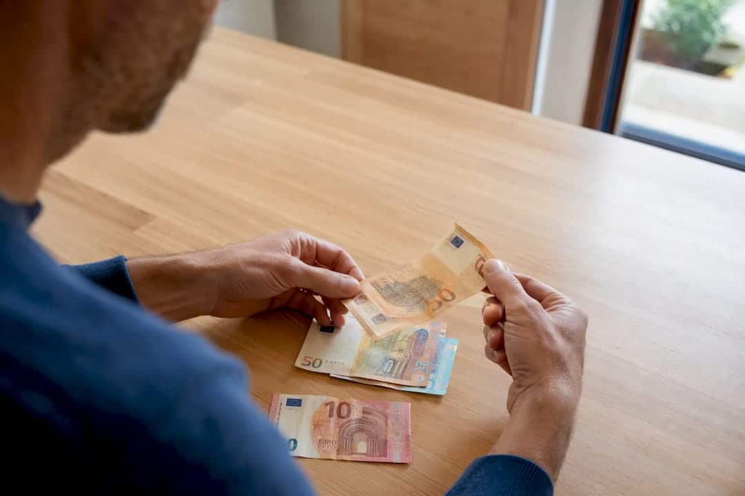 Mani che contano banconote in euro per un rimborso